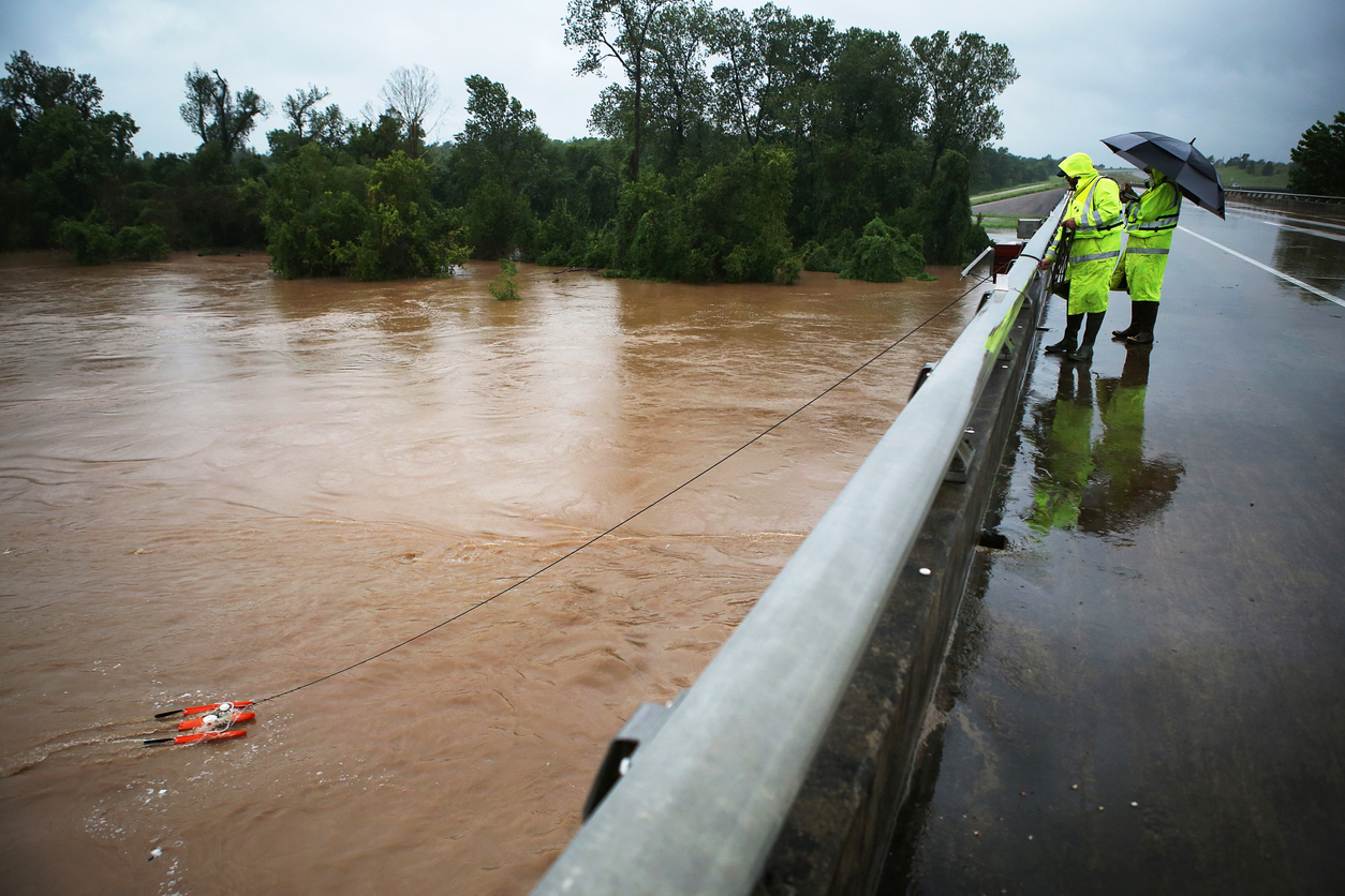 One result of climate change is more frequent and more powerful natural disasters, like hurricanes. Pictured are specialists testing the flooded river during Hurricane Harvey