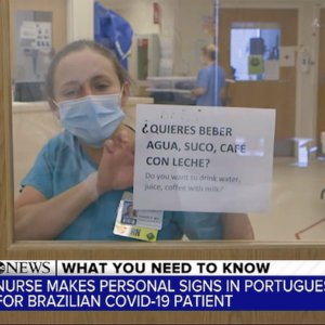 Danielle Fenn holds up sign she made for Brazilian COVID patient.