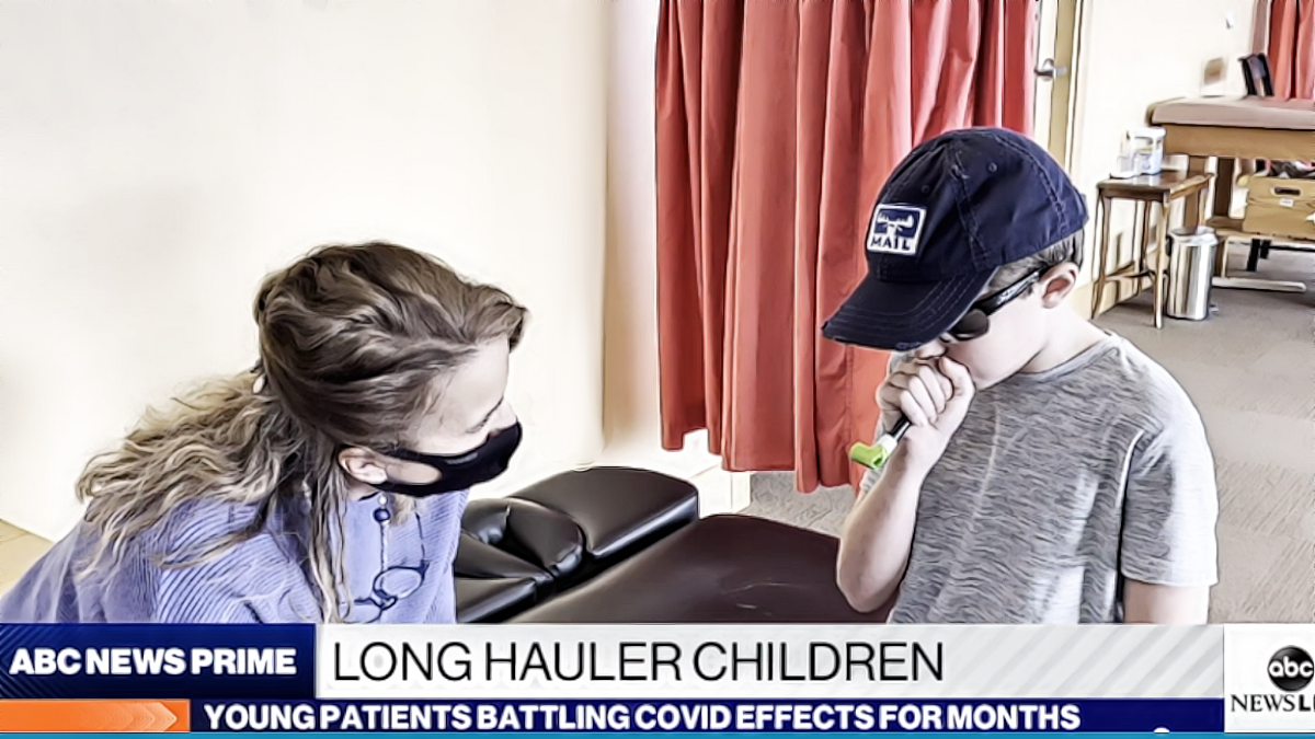A pediatric nurse works with a child Covid "long-hauler" patient.