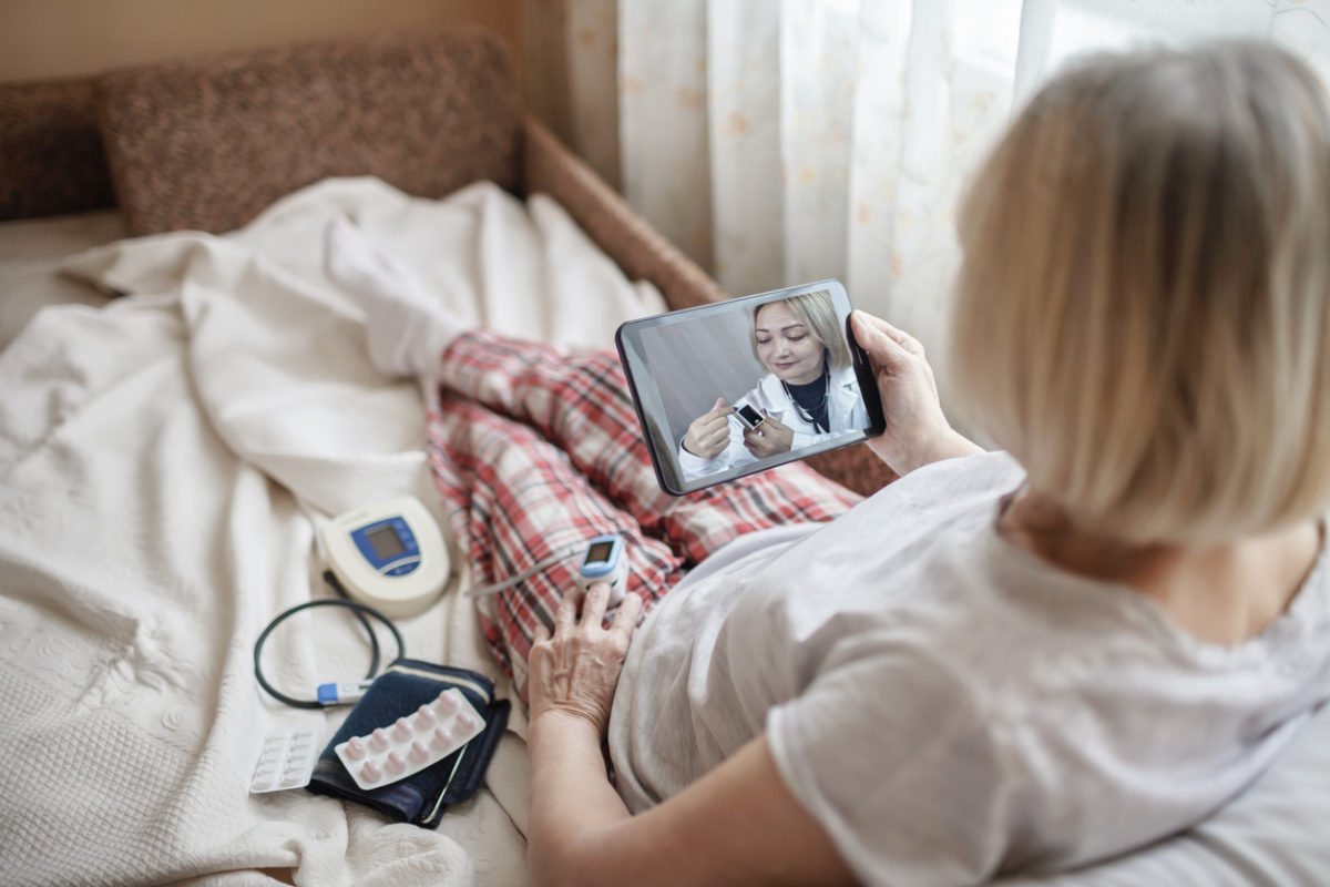Remote patient monitoring. Woman checks glucose levels at home.