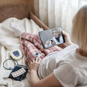 Remote patient monitoring. Woman checks glucose levels at home.