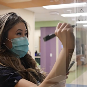 Texas pediatric ICU nurse Ly Truong paints a window mural in the kids' ICU.