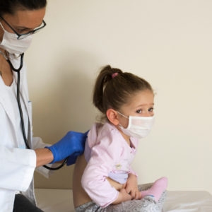 An FNP (family nurse practitioner) listens to a child's heart.