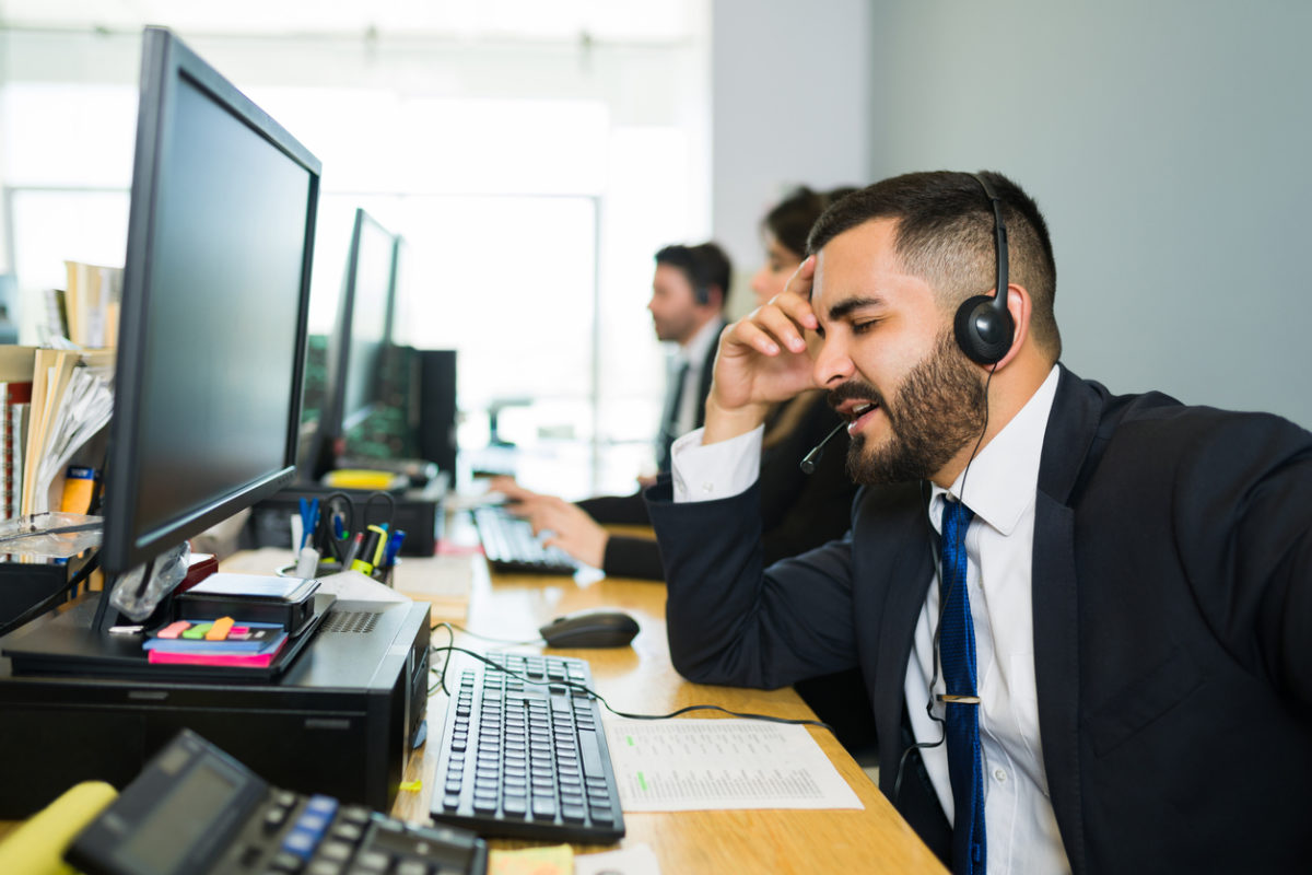 Tired customer service representative wearing headset.