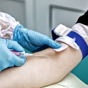 Typical nursing duties: a nurse draws blood from a patient.