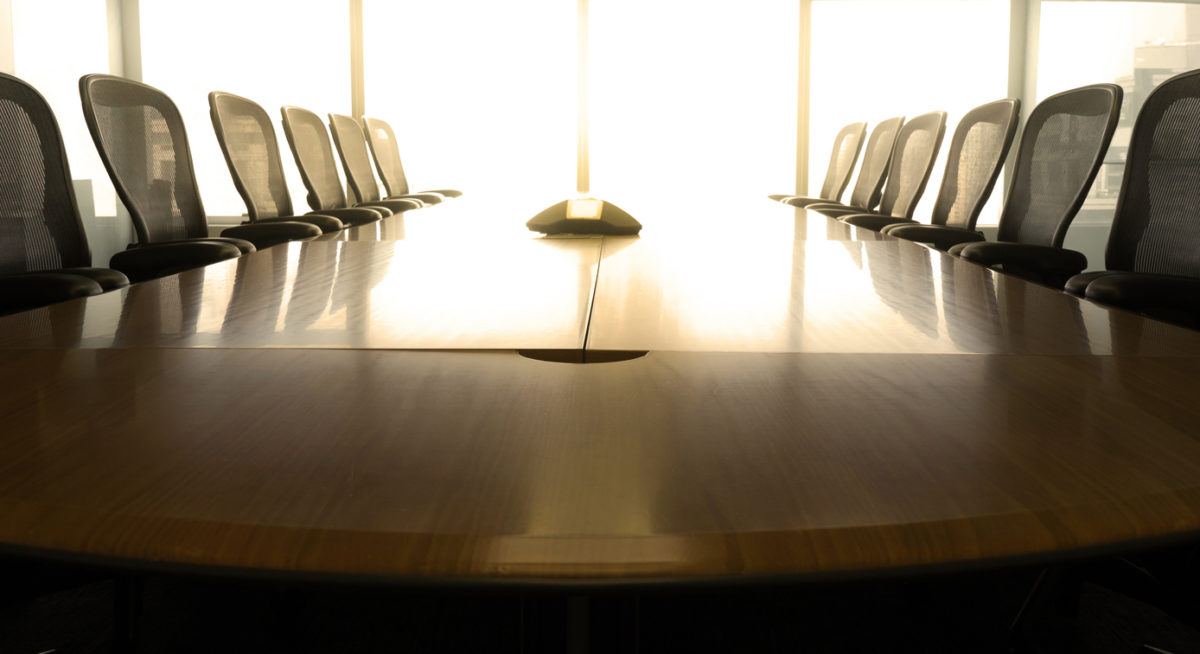 A boardroom table with empty chairs.