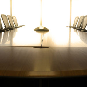 A boardroom table with empty chairs.