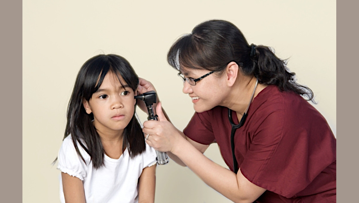 A family nurse practitioner or NP examines a child's ear.