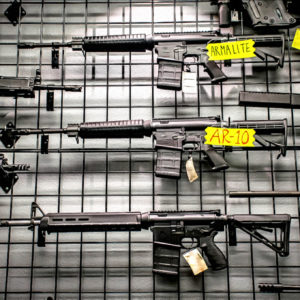 AR rifles and other firearms on display in a shop./