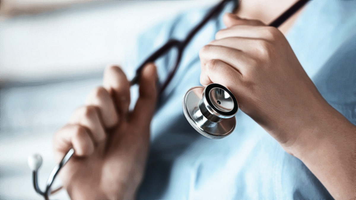 Nurse's hands holding a stethoscope.