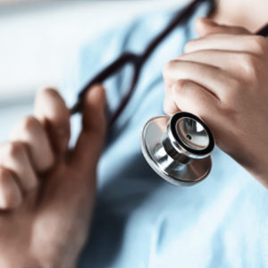 Nurse's hands holding a stethoscope.