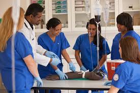 nursing students working in a lab as they go back to school in blue scrubs