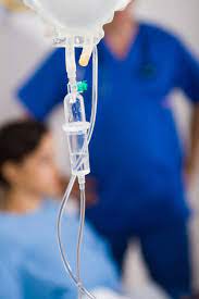 Infusion bag and two blurred people in background for IV Nurses
