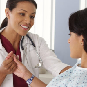 Latinx Hispanic FRNP (Family Nurse Practitioner) with patient.