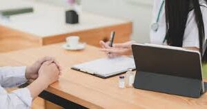 two people facing each other --hands only visible--with a laptop for professional development