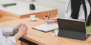 two people facing each other --hands only visible--with a laptop for professional development