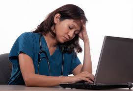a nurse in teal scrubs sleeping at a computer laptop