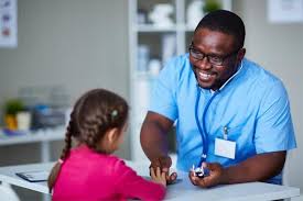 a male pediatric nurse with a female child patient